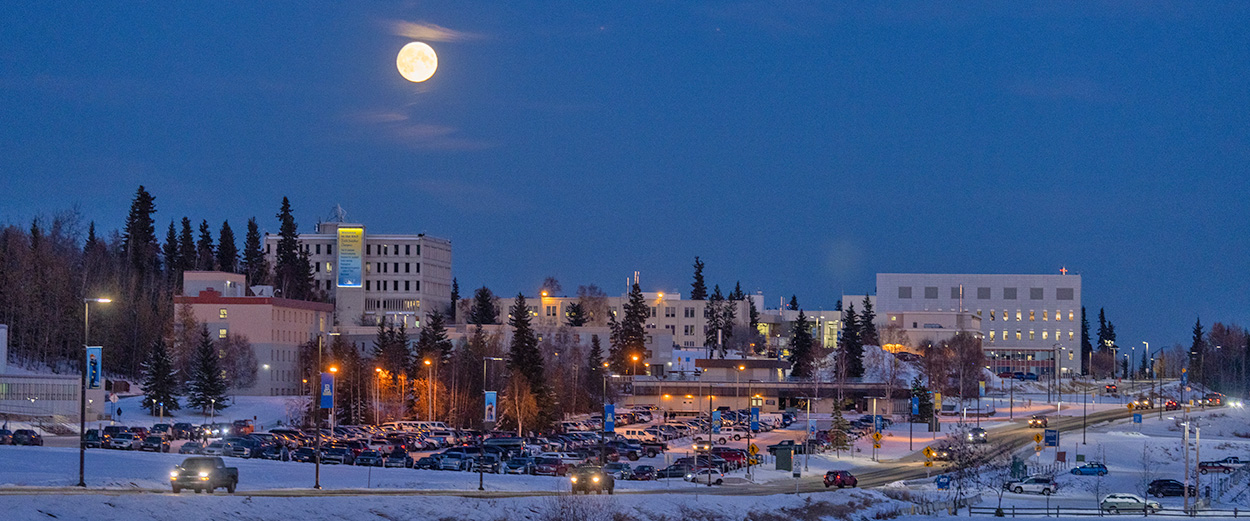 A winter full moon shines over the lower UAF Troth Yeddha campus in Fairbanks